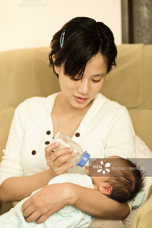 年轻的母亲正在喂养刚出生的婴儿图片素材