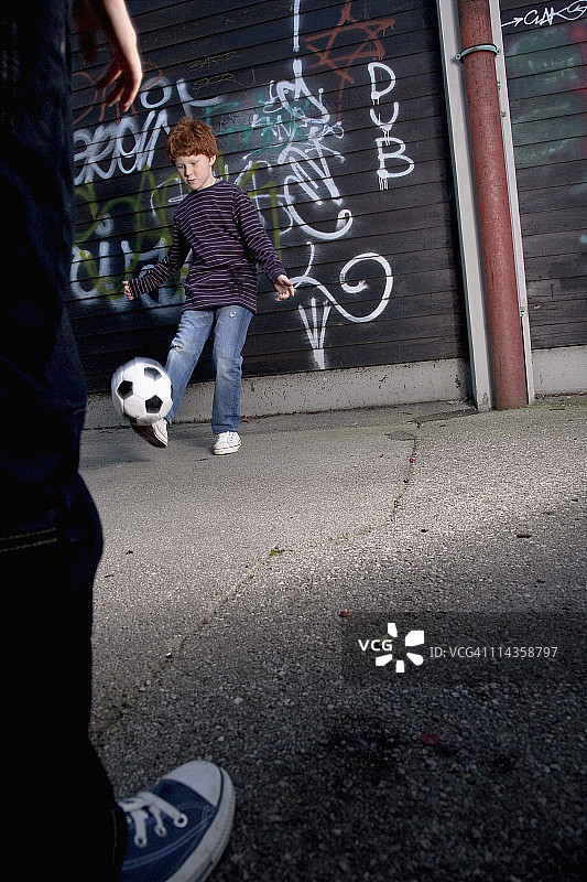 两个小男孩在玩街头足球图片素材