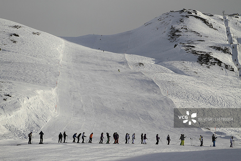 一队滑雪者在瑞士乌里坎顿安德马特的奥伯阿尔普山口等待滑雪缆车图片素材
