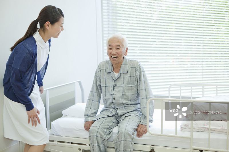 日本本州神奈川县，一位老人坐在医院病床上图片素材