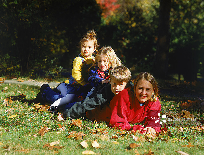 母亲和三个孩子躺在草地上图片素材