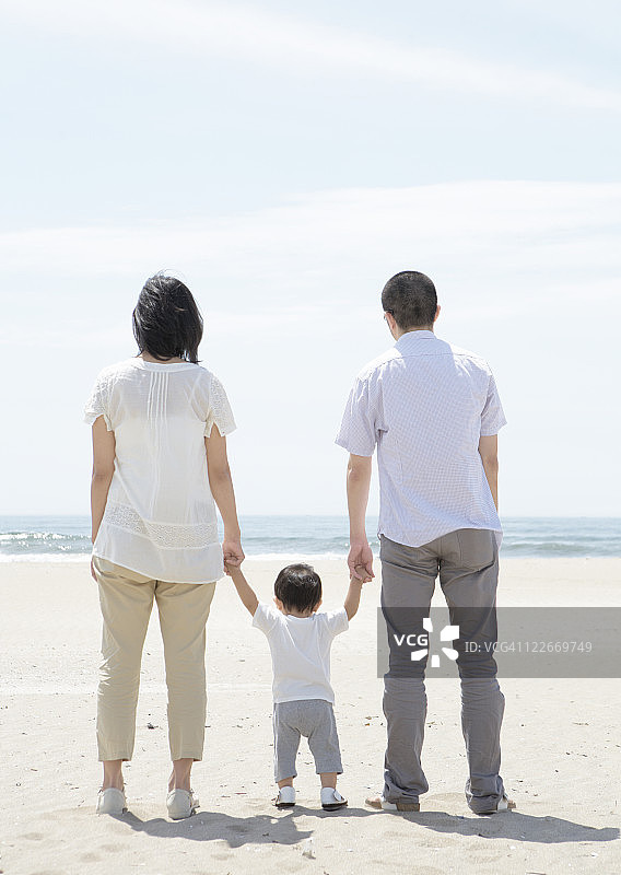 父母和孩子站在沙滩上图片素材