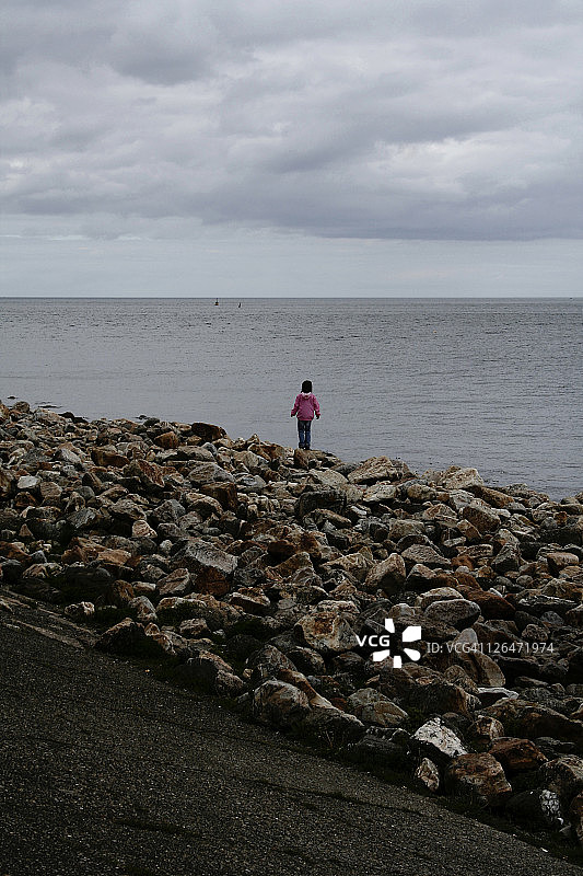 站在海滩岩石上的女人图片素材