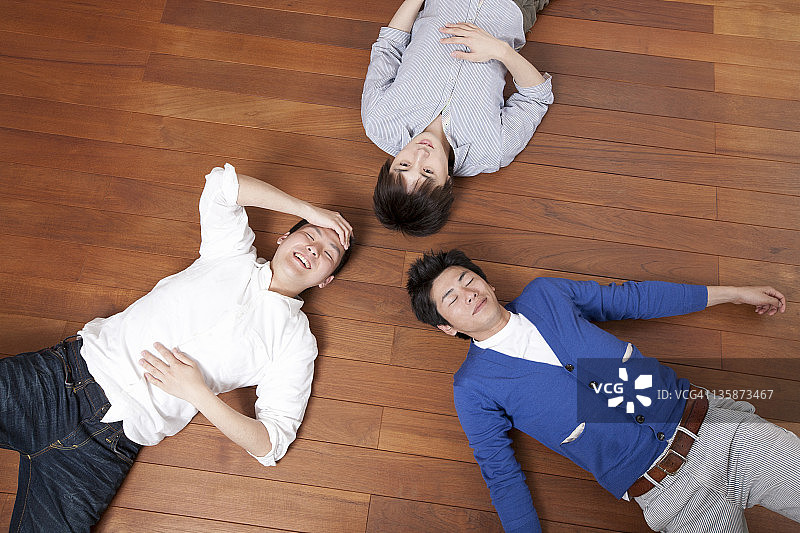 三个男人在硬木地板上休息图片素材