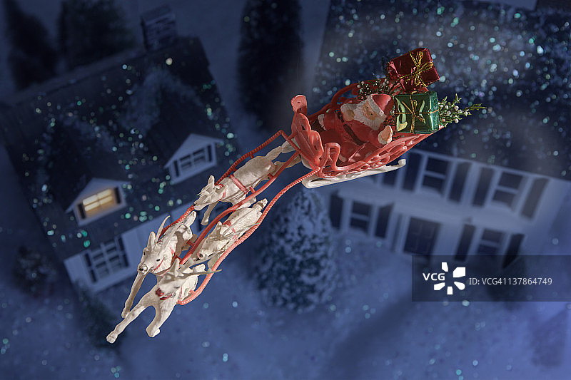玩具圣诞老人和雪橇越过房子图片素材