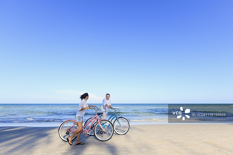 在海滩上骑自行车的成熟夫妇图片素材