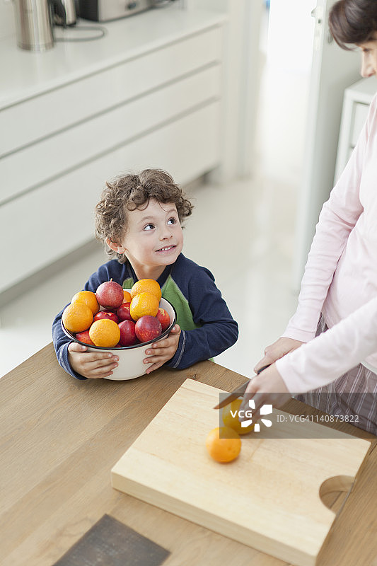 母亲和儿子在厨房切水果图片素材