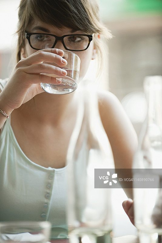 年轻女子用玻璃杯喝水图片素材