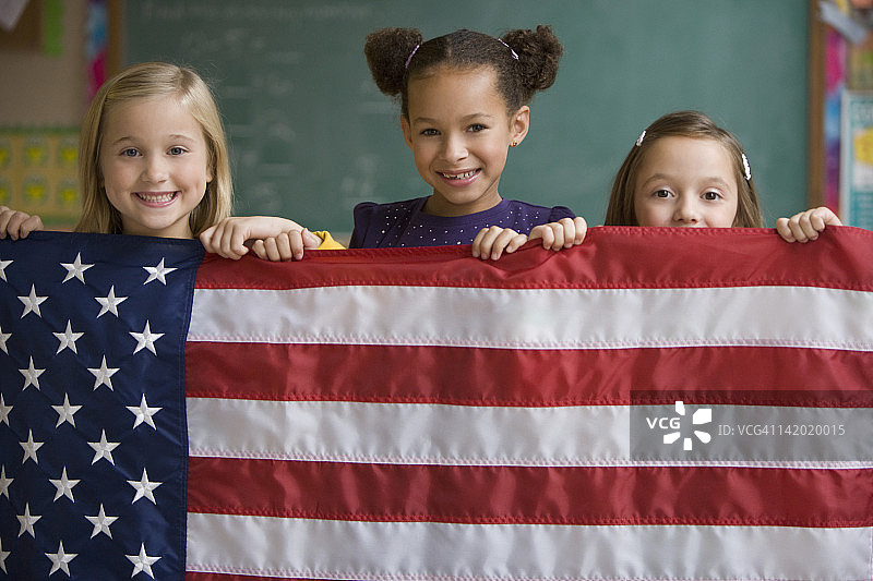 学生在教室里举着美国国旗图片素材