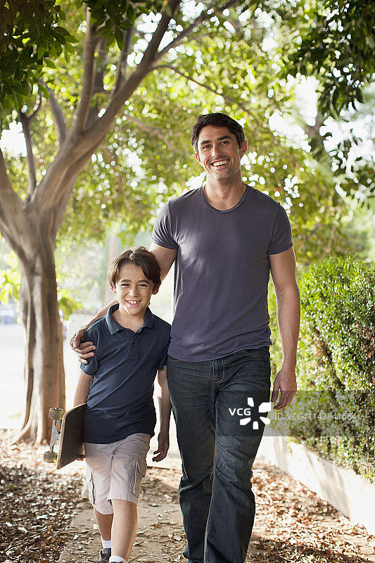 父亲和儿子走在郊区的街道上图片素材