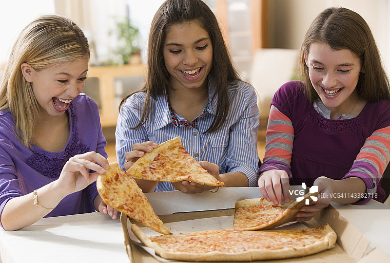 饥饿的女孩在吃披萨图片素材