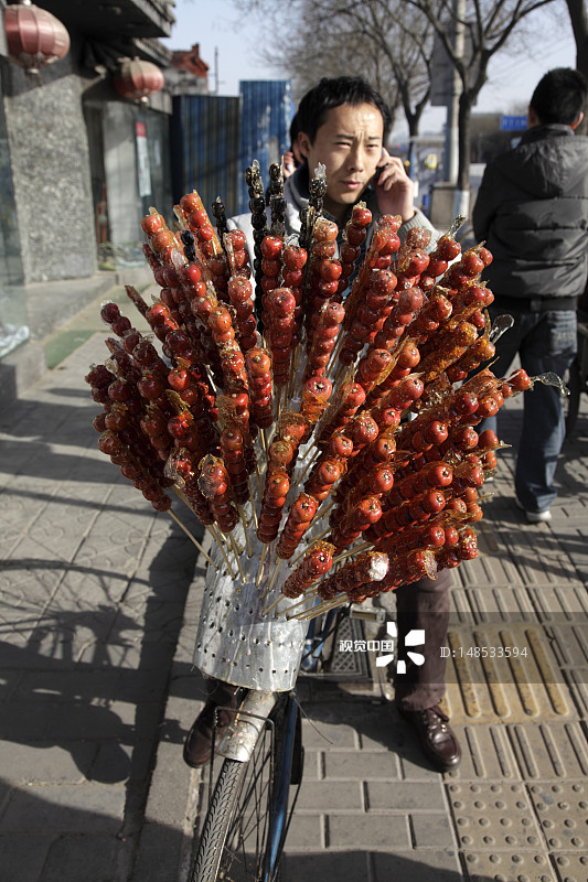 街头小贩在自行车上卖糖葫芦(又名葫芦)。图片素材