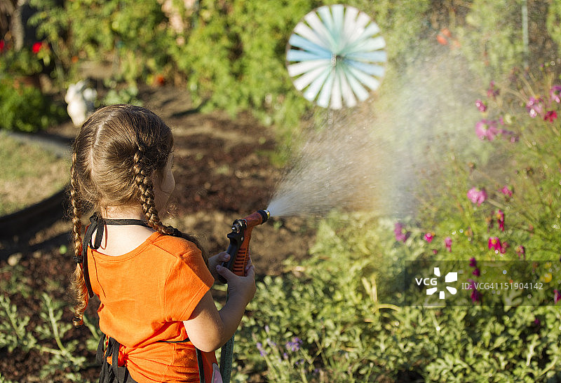 小女孩在花园浇水图片素材