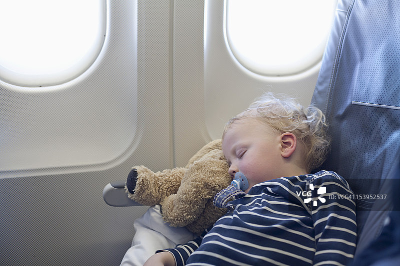 德国，男孩睡在飞机上图片素材