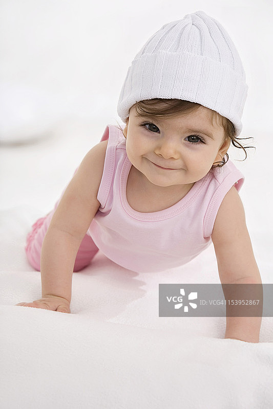 女婴在婴儿毯上爬行图片素材
