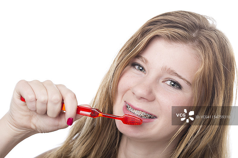 年轻女子戴着牙套刷牙图片素材