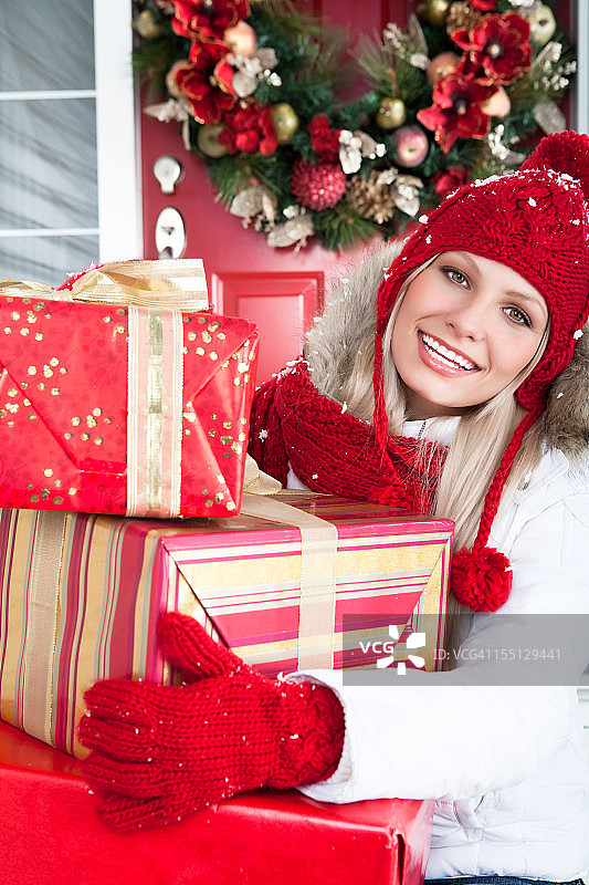 微笑着拿着圣诞礼物的女人图片素材