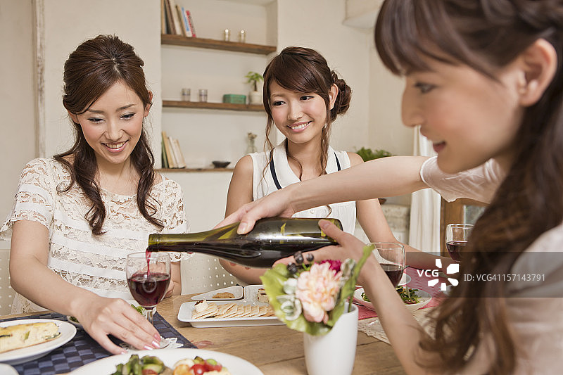三个年轻女人在派对上享用美酒图片素材