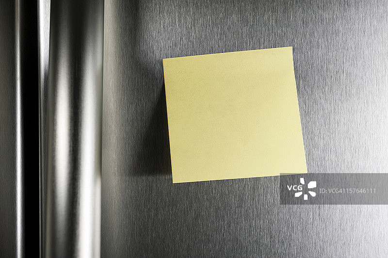 在不锈钢冰箱门上贴一张空白的便条图片素材