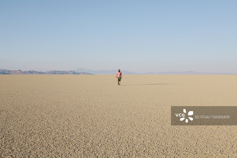 一名男子正穿过一片平坦的沙漠图片素材