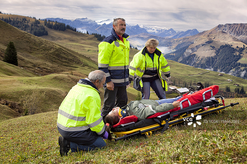 瑞士医护人员在阿尔卑斯山照顾受伤的妇女图片素材