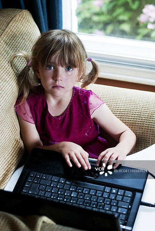 小女孩在用笔记本电脑图片素材