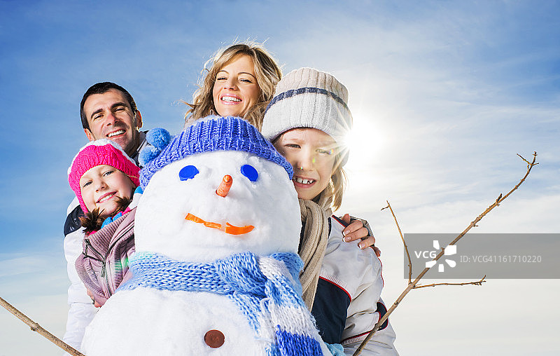 一家人堆了一个雪人。图片素材
