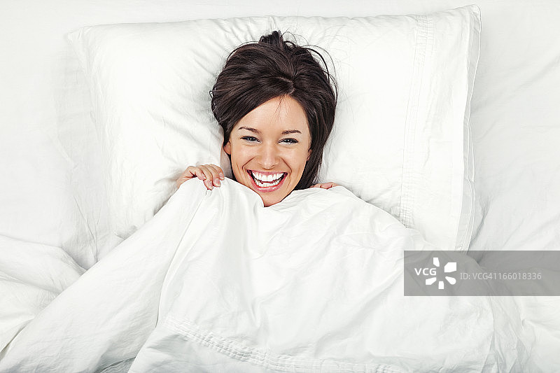 床上快乐的年轻女人图片素材