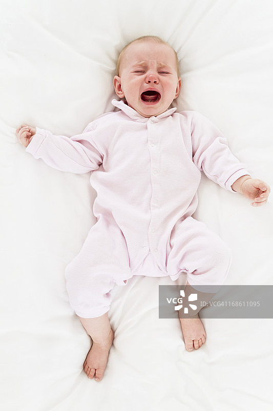 哭闹的婴儿躺在床上图片素材