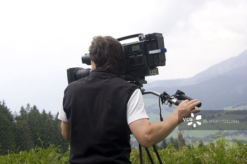 在山上操作摄像机的人图片素材