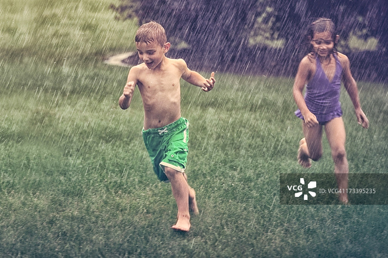 小男孩和小女孩在暴风雨中奔跑图片素材