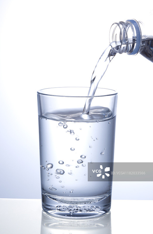 一杯水倒在白色的背景上图片素材