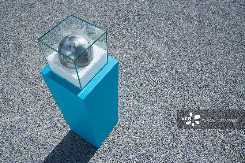 水晶球装在玻璃盒子里，底座上装有砾石图片素材