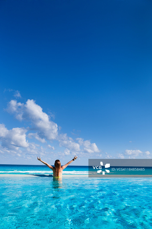 在加勒比度假酒店享受无限泳池的女人图片素材