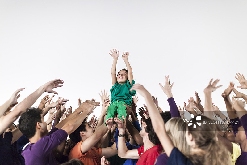 一群人举起一个孩子庆祝图片素材