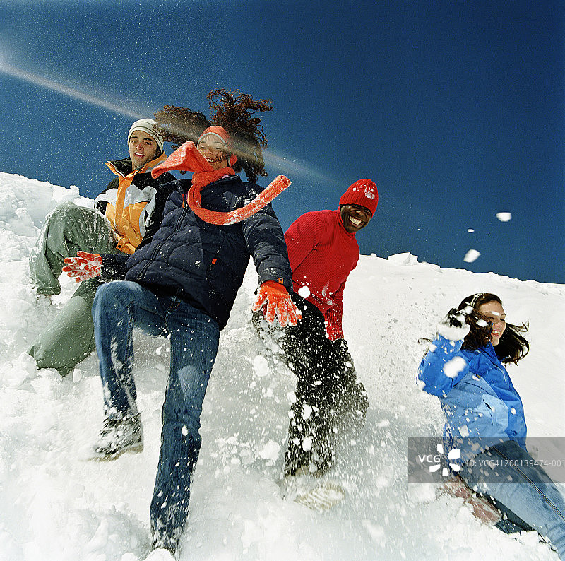 一群年轻男女从雪山上滑下来图片素材