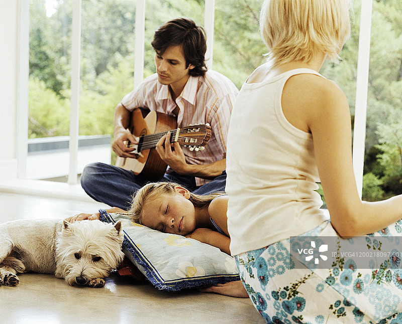 家人在室内放松，男人在弹吉他图片素材