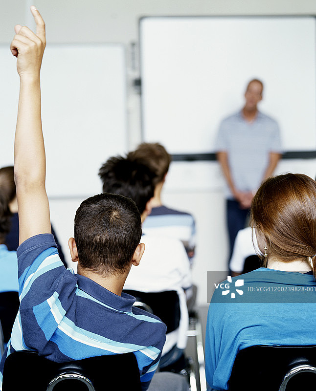 男生(14-16岁)在课堂上举手，后视图图片素材