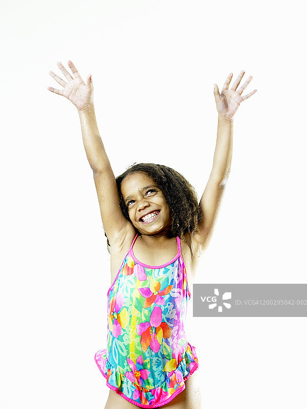 穿着泳衣的女孩(6尺8寸)微笑着在空中举起手臂图片素材