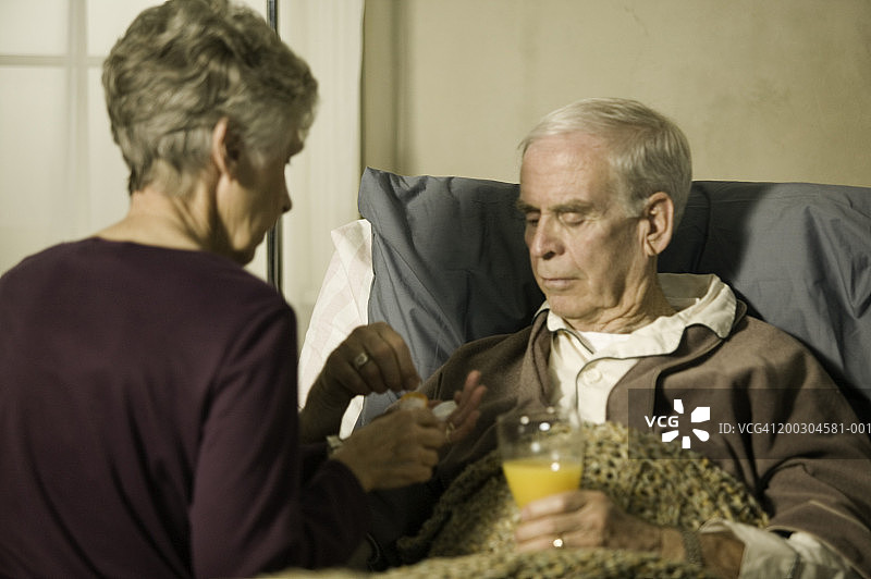 老医生在养老院给卧床的老人开药图片素材