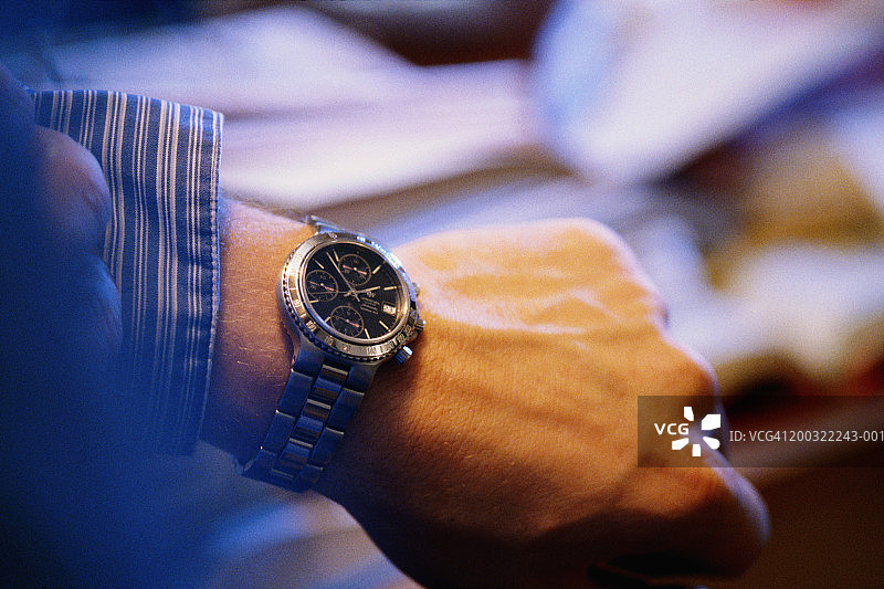 男人在手表上看时间，特写图片素材