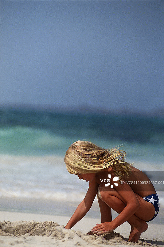 女孩(6-7)在沙滩上玩沙子图片素材