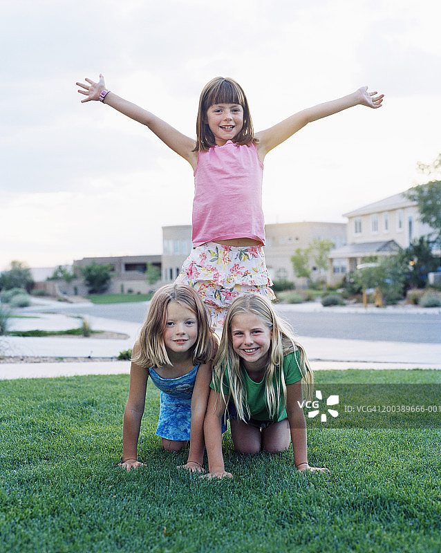 夏天，女孩们(7-11岁)在草坪上做金字塔图片素材