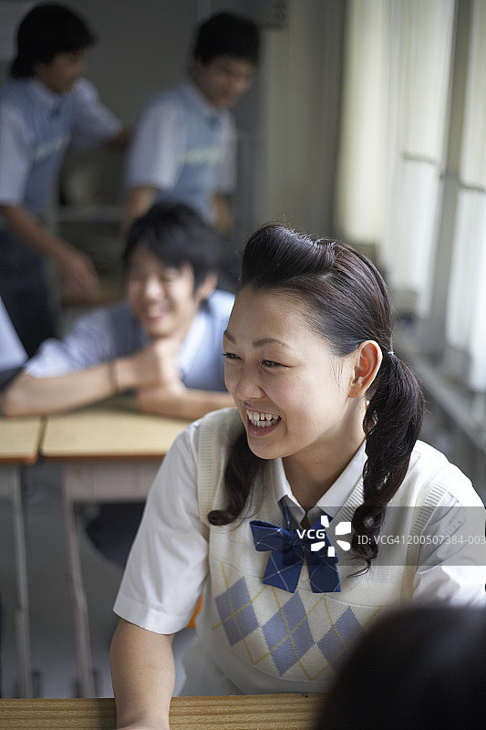 十几岁的学生(13-18岁)在教室里，女孩笑着图片素材