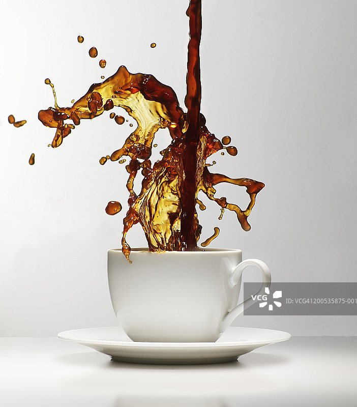 咖啡倒在杯子里溅起水花图片素材