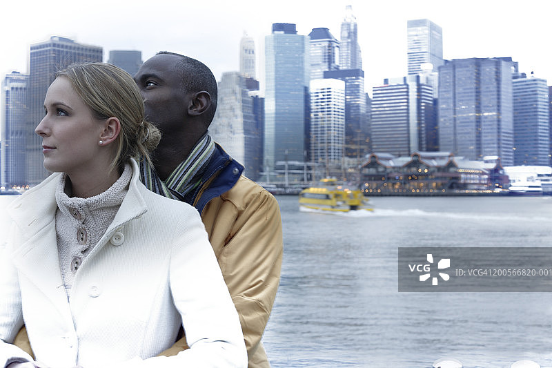 美国，纽约，一对情侣在曼哈顿的天际线下拥抱，上半部分图片素材