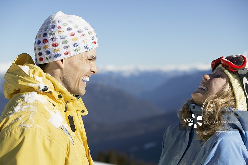 一对在滑雪山上大笑的夫妇图片素材