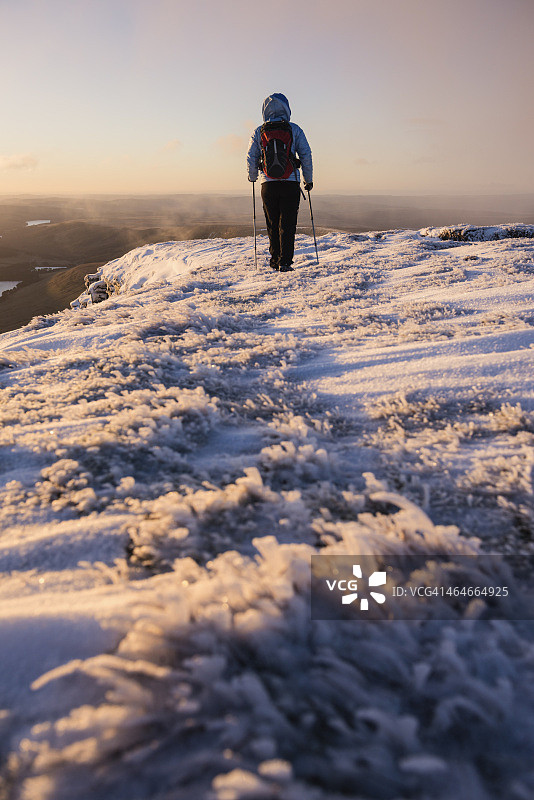 女徒步者在日出的冬季高峰Pen Y Fan，布雷肯灯塔国家公园，威尔士图片素材