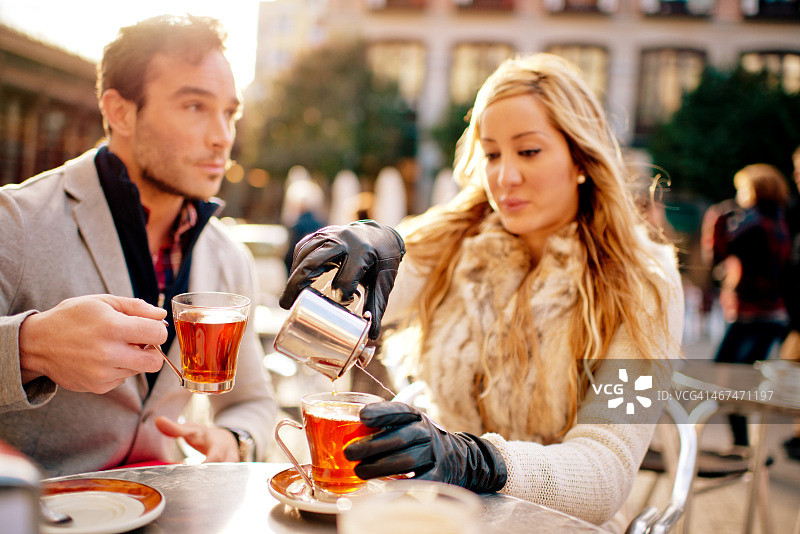 一对夫妇在室外咖啡馆喝热茶，马德里图片素材