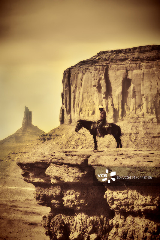 狂野西部牛仔骑在马在旧复古古色古香色调图片素材